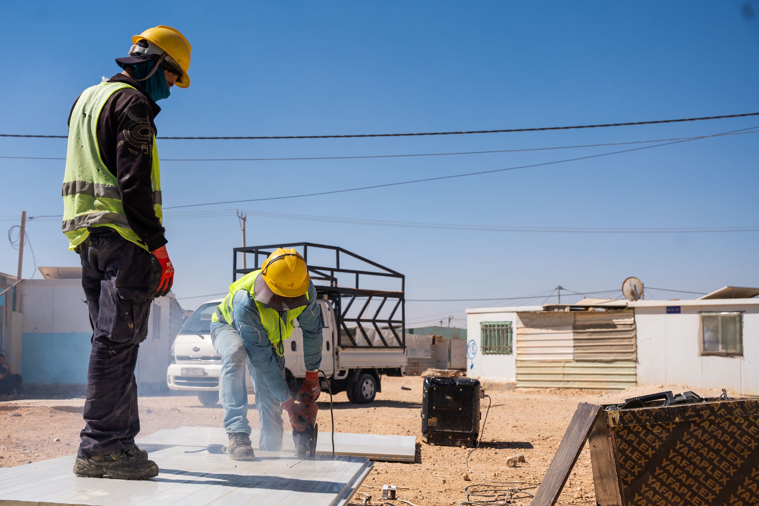 Two people doing construction work.
