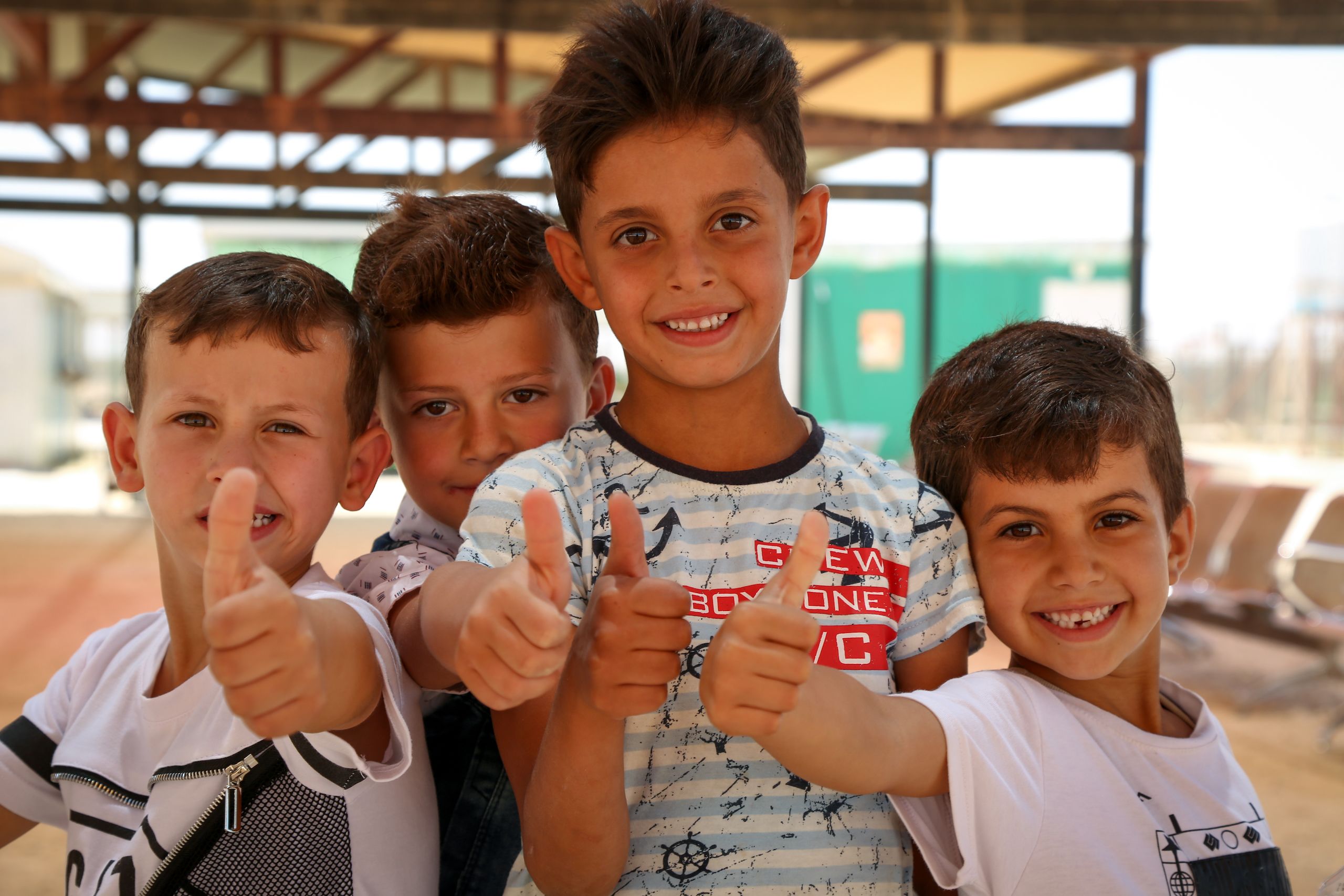 Four boys holding thumbs up.