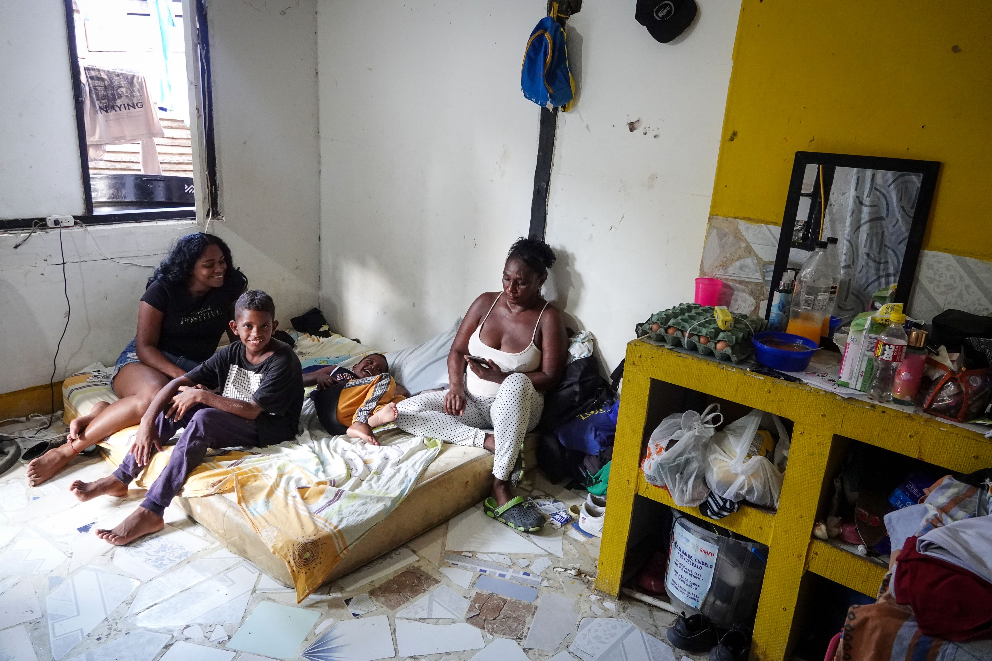 Petra sitting on a mattress on the floor along with her family.