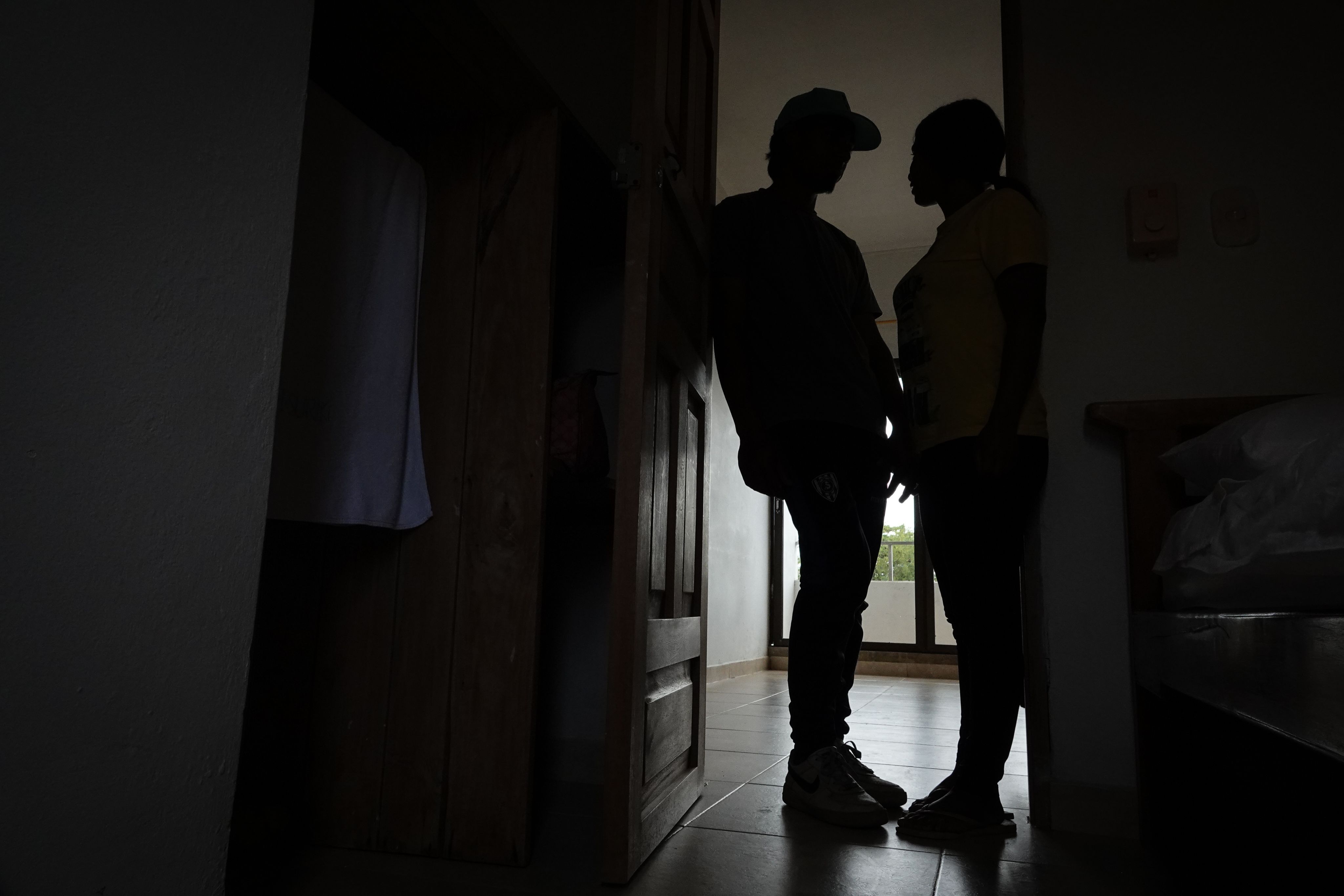 Silhouette of a man and woman standing in a doorway.