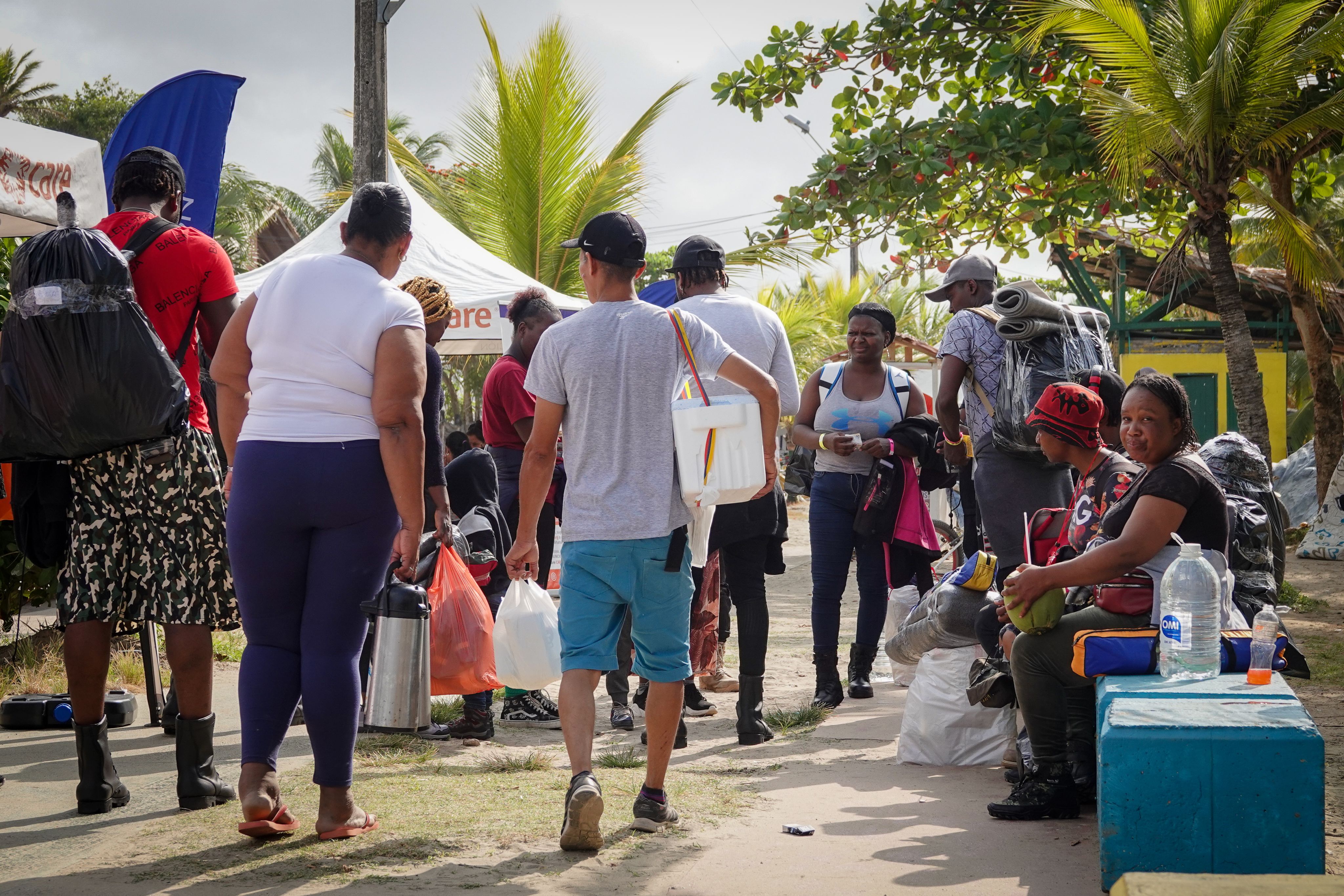 People walking carrying their belongings. 