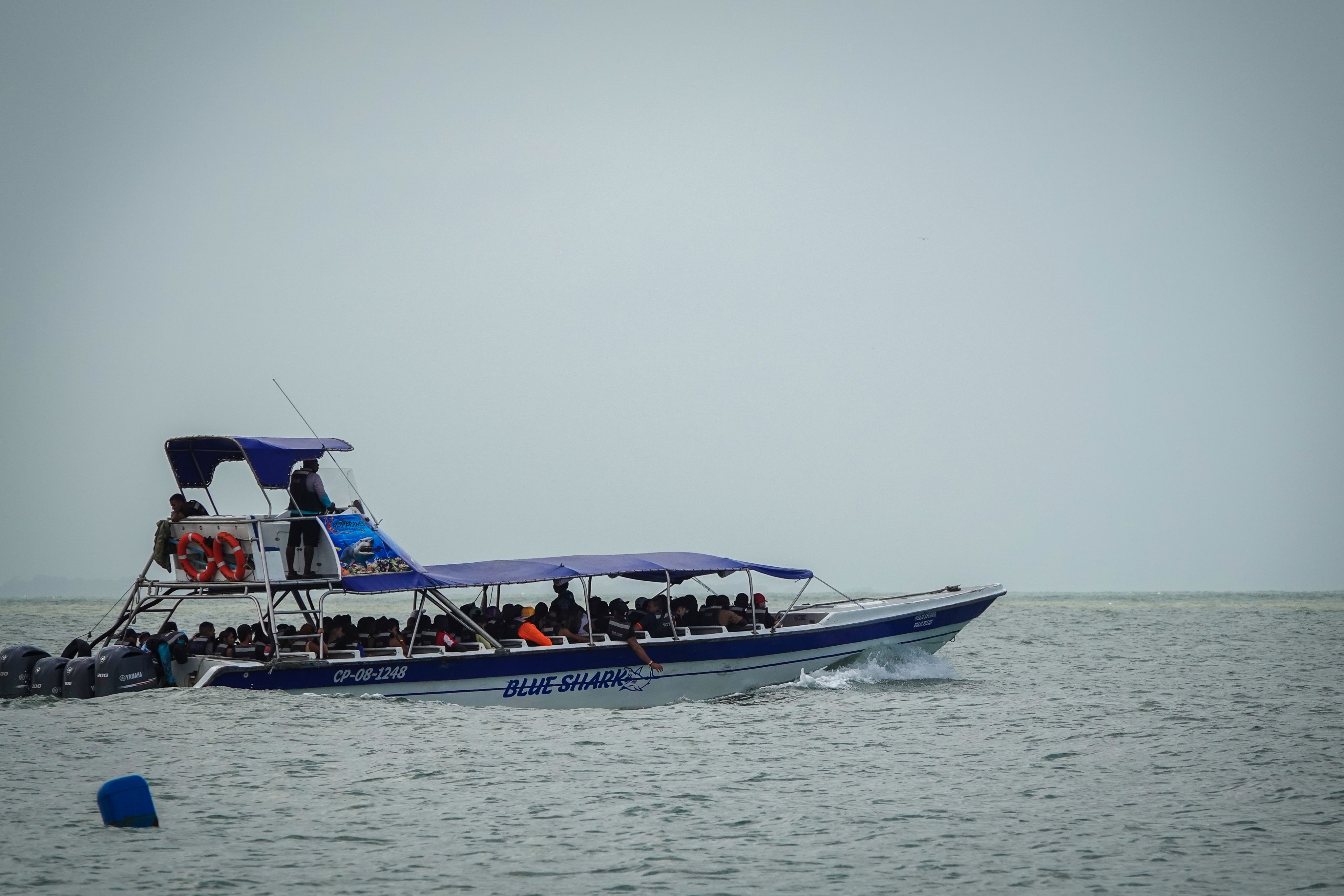 Boat carrying passengers crossing a body of water